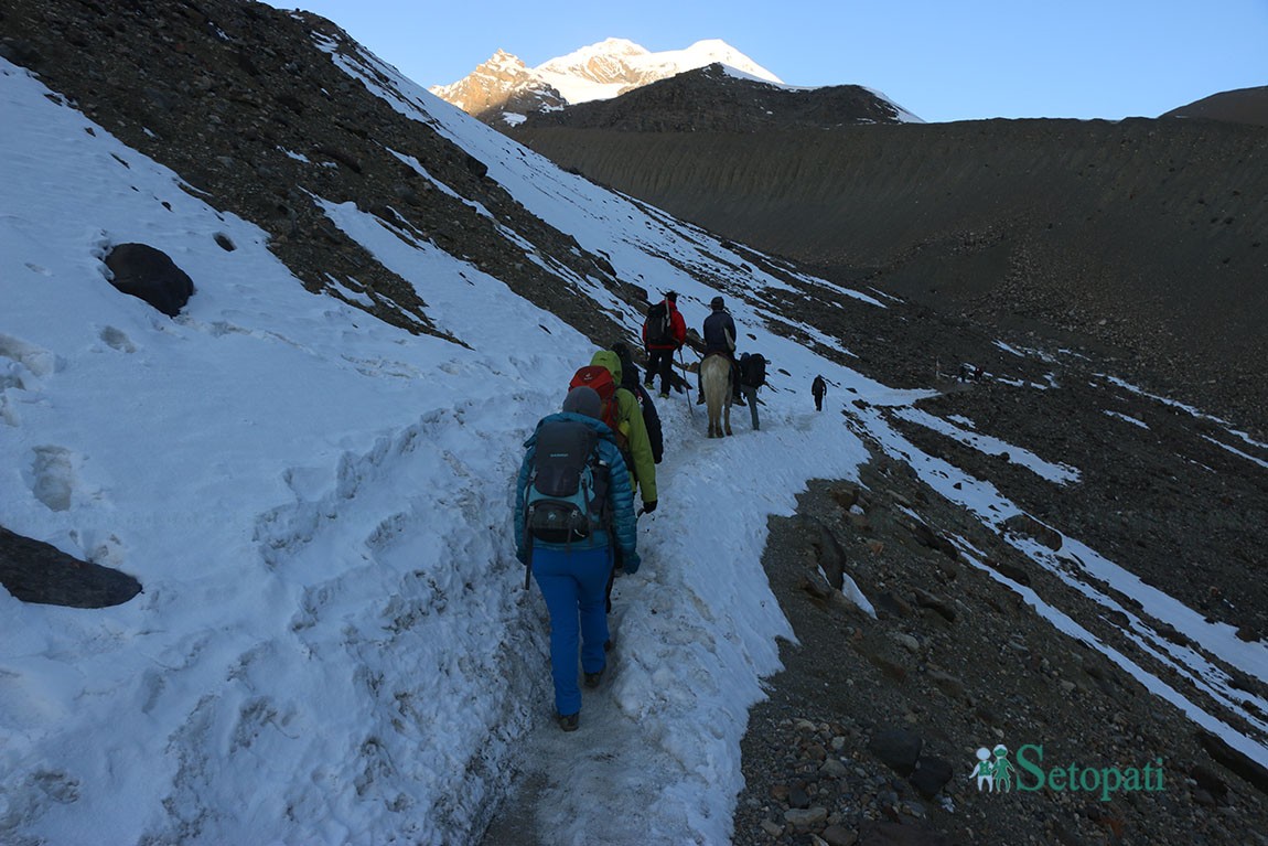 थोराङपास गर्नेक्रममा हाइक्याम्पबाट उकालो चढ्दै गरेका पर्यटकहरू। तस्बिरः रमेश