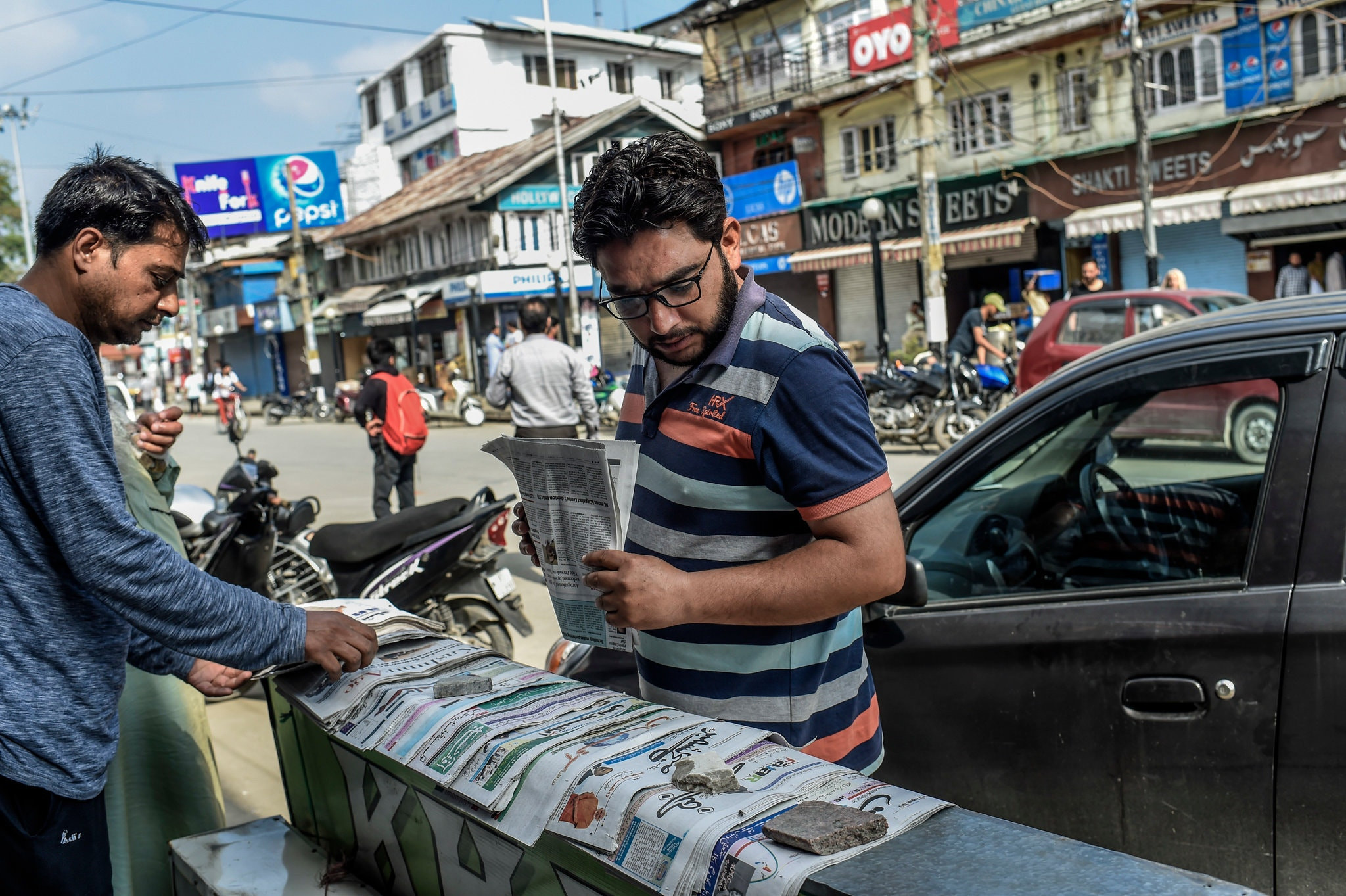 कश्मिरमा अखबार हेर्दै। तस्बिरः द न्यूयोर्क टाइम्स