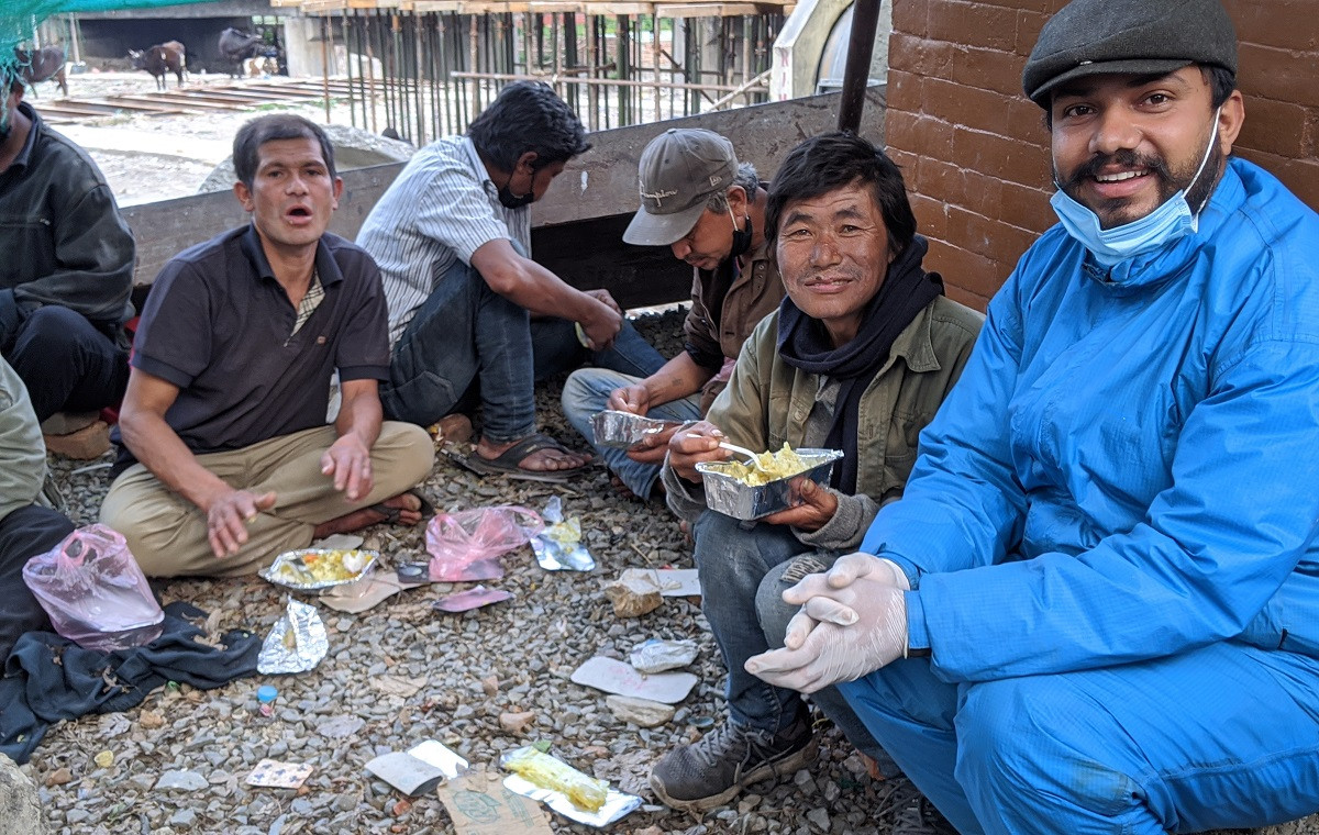 अजय अधिकारी भोकाहरूलाई खाना बाँड्दै।