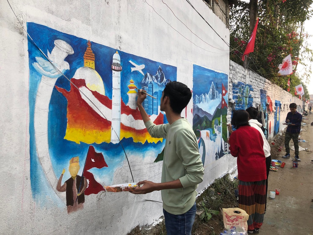 एमालेको दसौं महाधिवेशन क्रममा चितवनका कलाकारहरू सौराहाका सडक भित्तामा चित्र बनाउँदै। तस्बिर: राजेश घिमिरे/सेतोपाटी