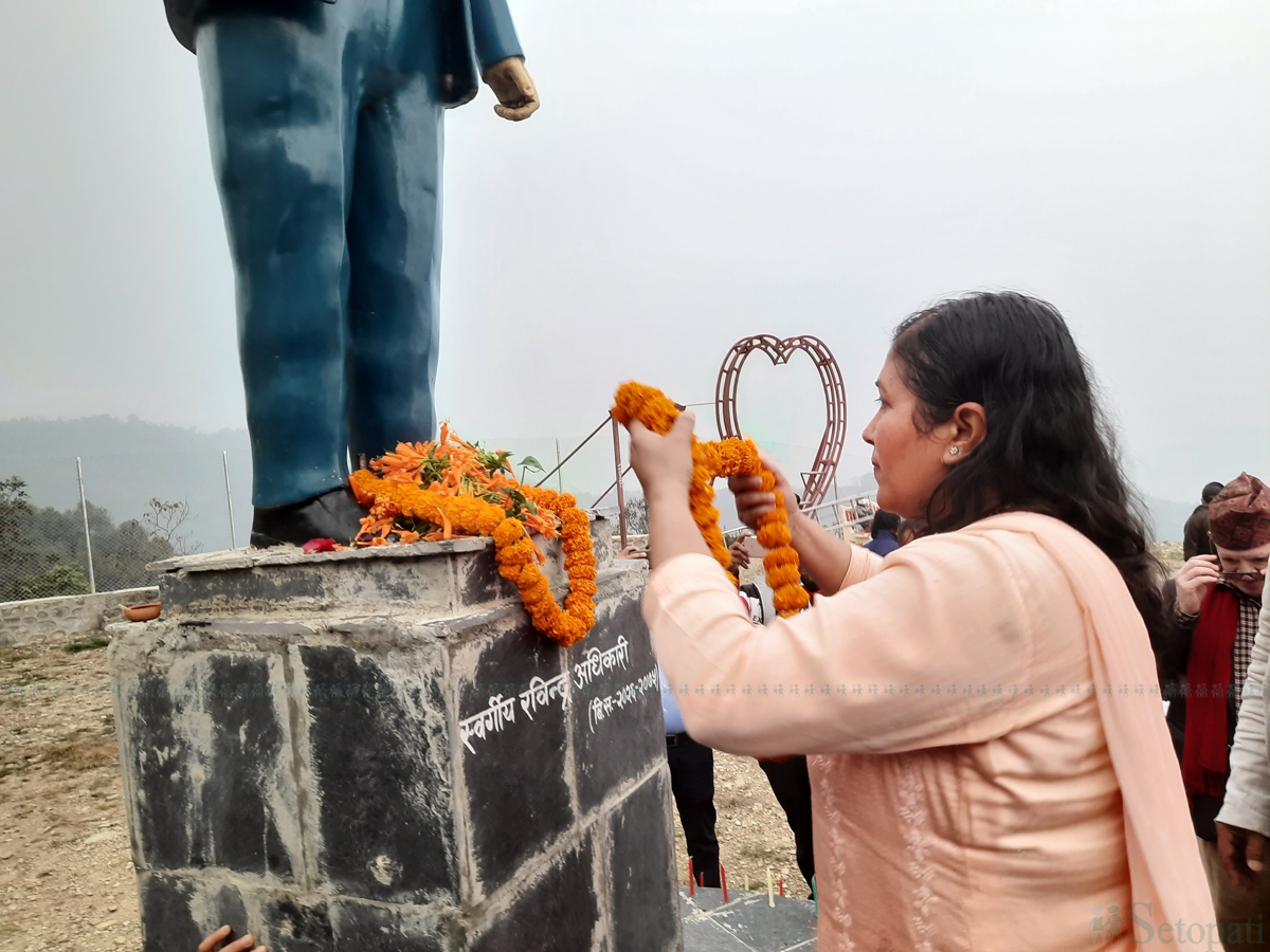 रवीन्द्र अधिकारीको शालिकमा पुष्प अर्पण गर्दै पत्नी विद्या। तस्वीर: युवराज श्रेष्ठ/सेतोपाटी।